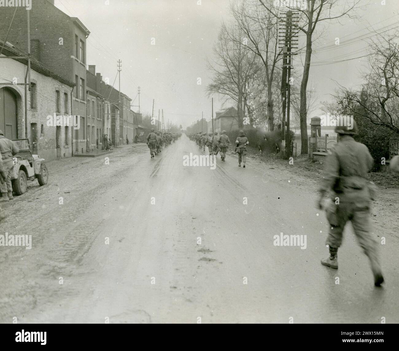 Fotos des Zweiten Weltkriegs: Originalunterschrift: 101. Airborne Infantry Division auf der Straße zwischen Bastogne und Hauffalige, Belgien, während sie sich auf den Weg zum deutschen Vortrieb begeben. Bastogne, Belgien." CA. Dezember 1944 Stockfoto
