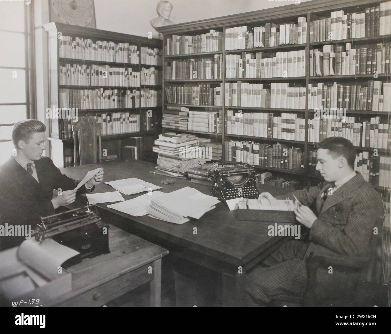 Dieses Foto zeigt zwei Studenten der Brown University, die die Harris Collection of American Poetry katalogisieren und in der John Jay Library als Teil eines College-Hilfsprojekts der National Youth Administration (NYA) CA spielen. 1939-1943 Stockfoto