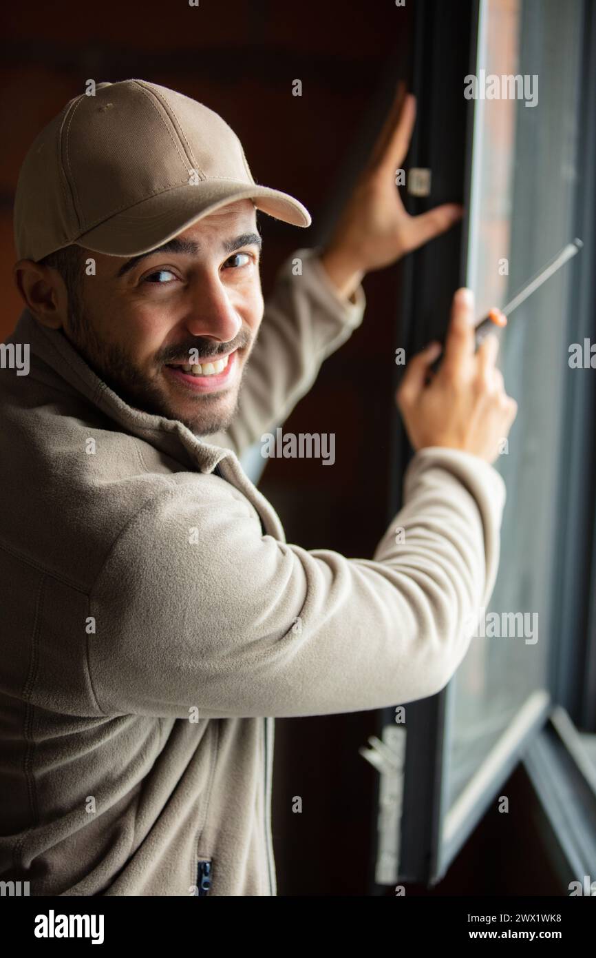 Junger Mann macht Fensterinstallation Stockfoto