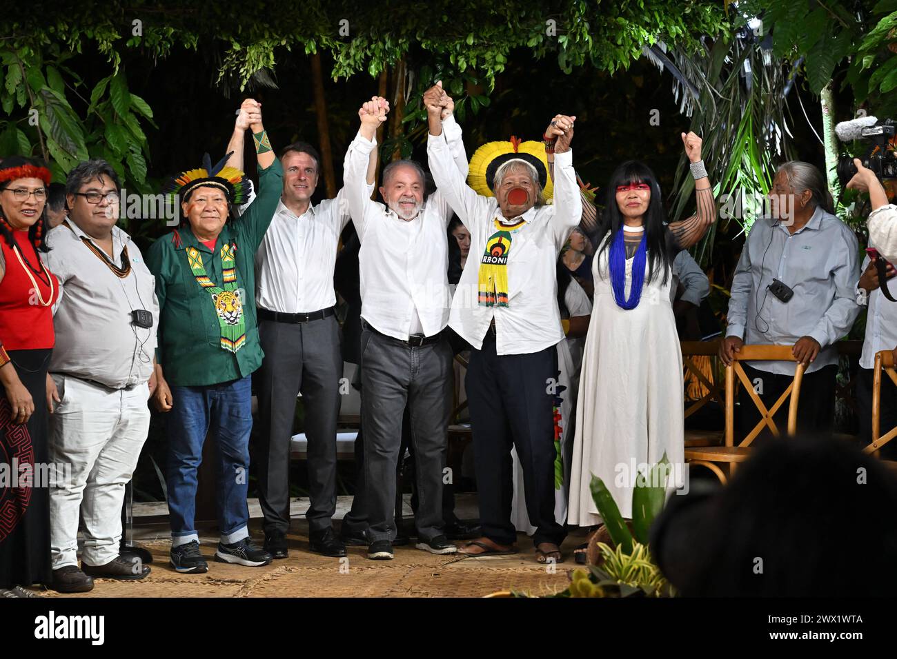 Der brasilianische Yanomami-Schamane und Sprecher des Volkes der Yanomami Davi Kopenawa Yanomami, der französische Präsident Emmanuel Macron, der brasilianische Präsident Luiz Inacio Lula da Silva, der brasilianische indigene Führer des Volkes der Kayapo, Raoni Metuktyre, und die brasilianische indigene Aktivistin und Leiterin des indigenen Frauenverbandes des Xingu Indigenous Park, Watatakalu Yawalapiti, winkte bei einem Treffen auf der Insel Combu vor Belem, Bundesstaat Para, Brasilien, am 26. März 2024. Die französischen und brasilianischen Präsidenten Emmanuel Macron und Luiz Inacio Lula da Silva starteten am Dienstag ein Programm, das darauf abzielte, bis zu einem zu erhöhen Stockfoto