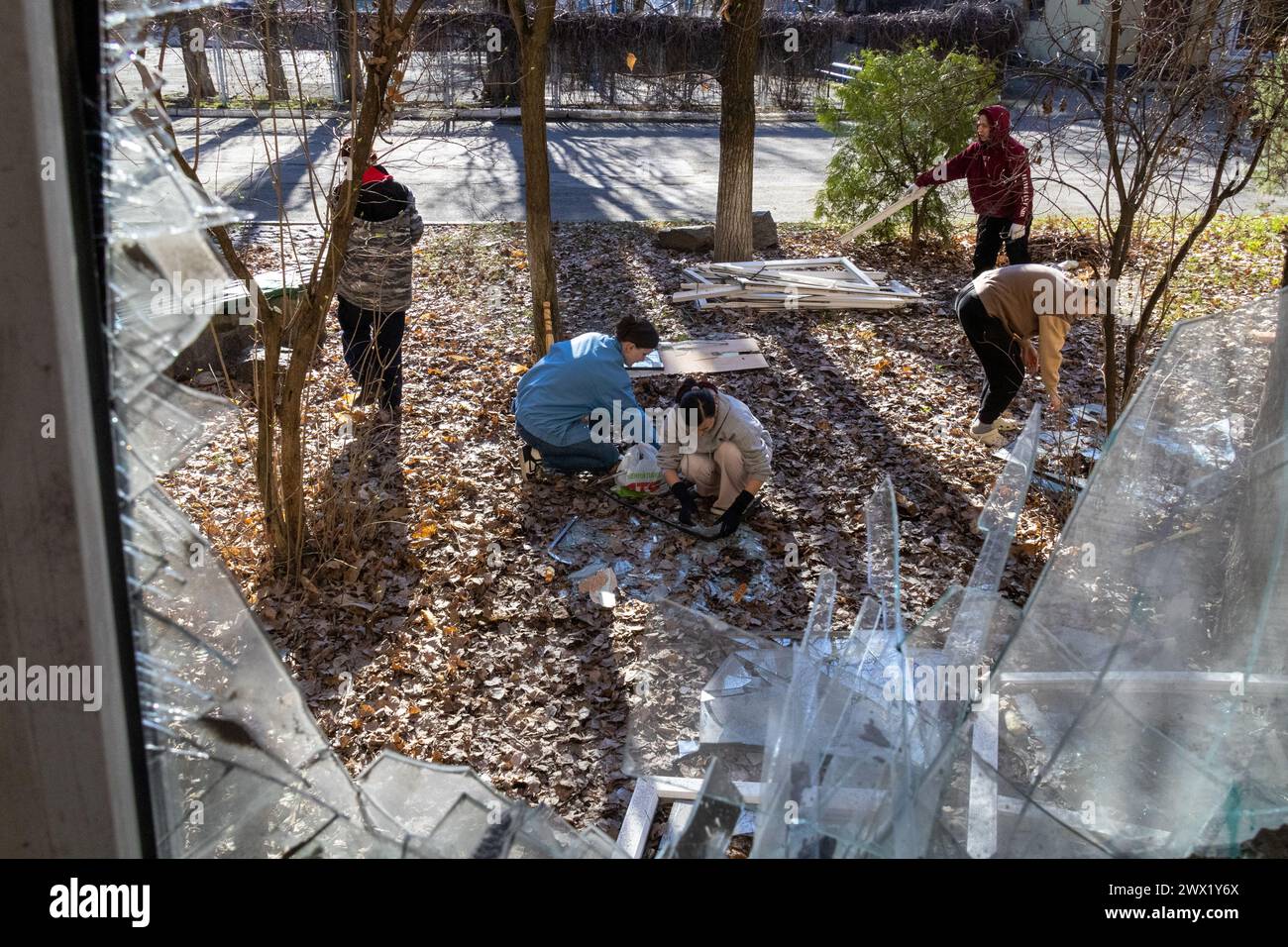 KIEW, UKRAINE - 26. MÄRZ 2024 - Menschen sammeln Glasscherben an der Staatlichen Akademie für dekorative und angewandte Kunst und Design Mykhailo Boichuk Kiew im Bezirk Petscherskyi, das durch den Sturz einer abgestürzten russischen ballistischen Rakete zerstört wurde, Kiew, Hauptstadt der Ukraine. Wie berichtet, starteten russische Truppen am Montag, den 25. März, um etwa 10:30 Uhr Ortszeit zwei ballistische Raketen in die ukrainische Hauptstadt. Stockfoto