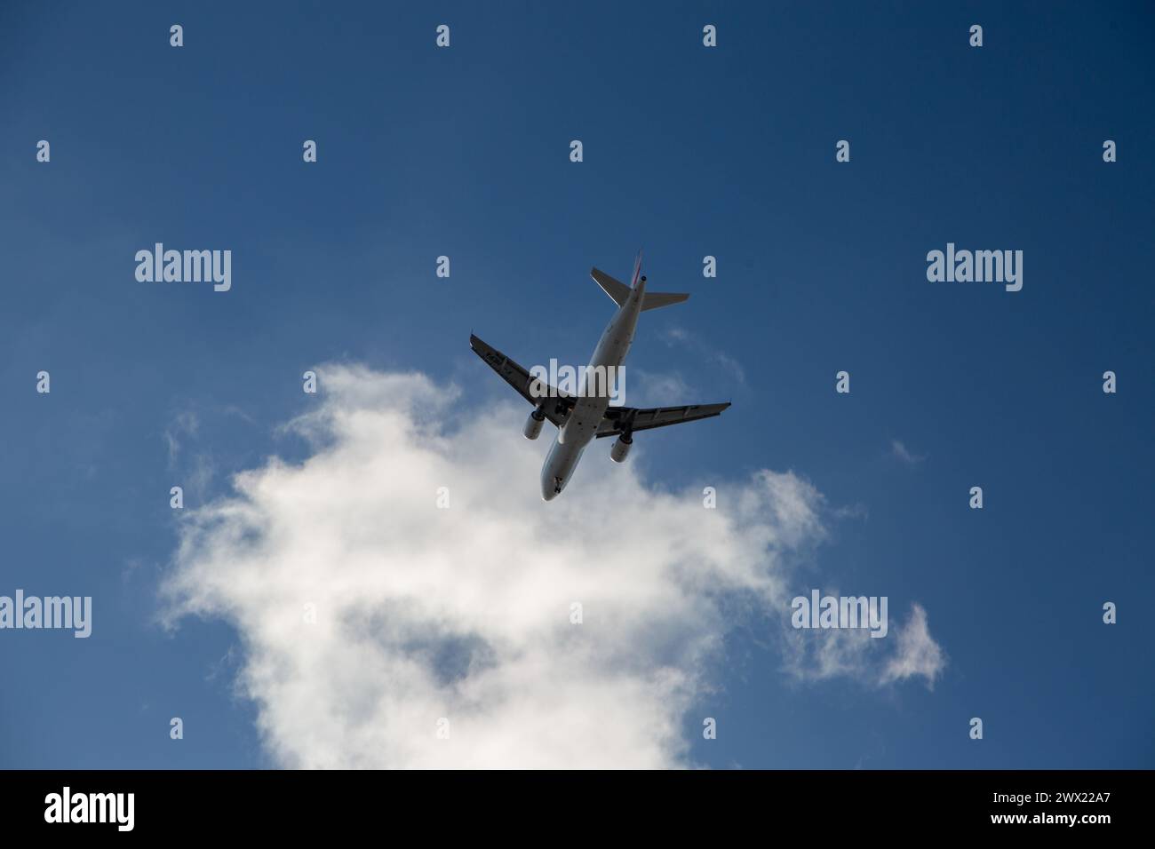 Jet-Flugzeug am Himmel mit Wolken in den Niederlanden Stockfoto