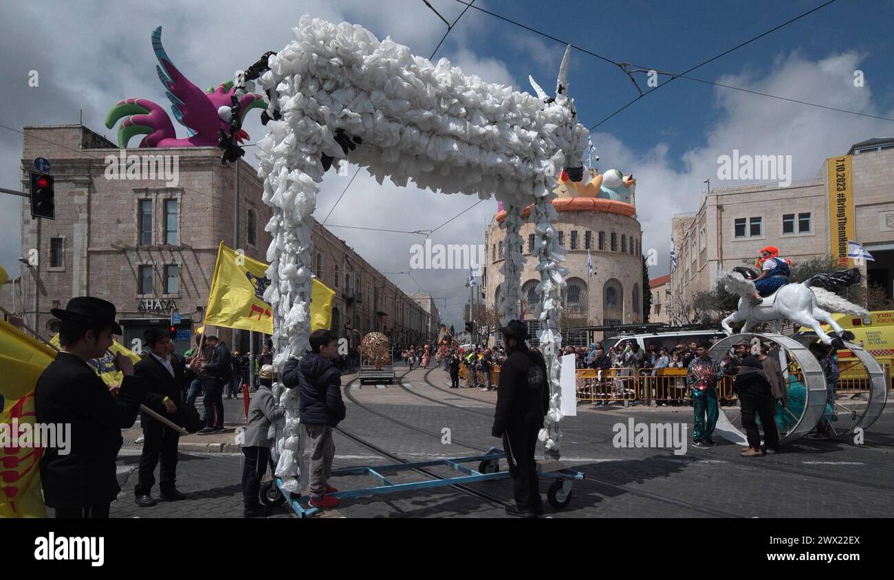 Menschen in Kostümen nehmen an einer Parade zum jüdischen Purimfeiertag Teil, die zum ersten Mal seit 42 Jahren in Jerusalem stattfindet, inmitten des anhaltenden Konflikts zwischen Israel und der palästinensischen islamistischen Gruppe Hamas am 22. März 2024 in Jerusalem. Israel Stockfoto