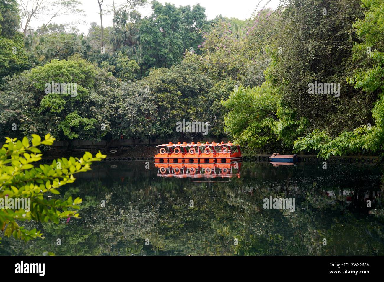 Malerische Aussicht auf einen Fluss mit Booten in einem grünen Park Stockfoto