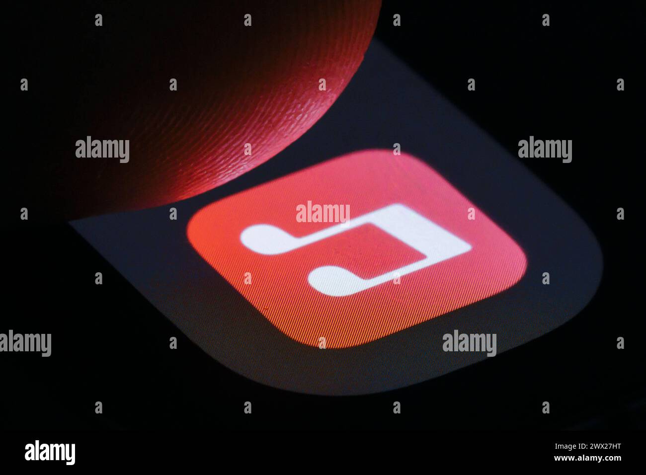 Die App von Apple iTunes ist auf einem Smartphone neben einem Finger zu sehen. Berlin, 27.03.2024. Berlin Deutschland *** die Apple iTunes App kann sein Stockfoto