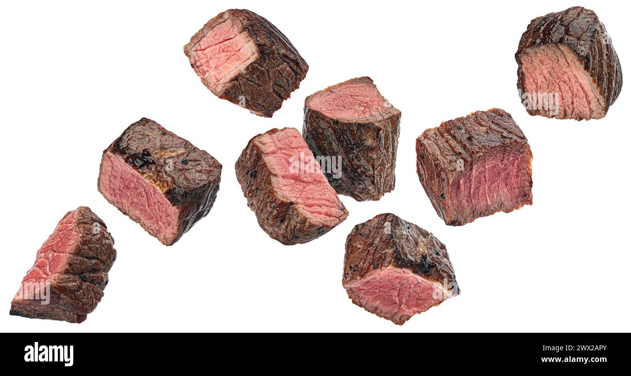 Mittelseltene Steakstücke, geschnittene gegrillte Rindfleischwürfel auf weißem Hintergrund Stockfoto