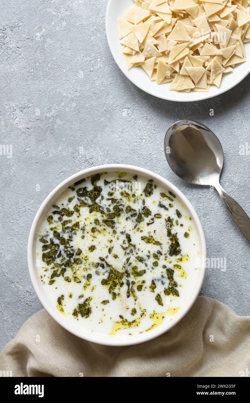 Traditionelle türkische hausgemachte dreieckige Joghurtteigsuppe mit Öl und getrockneten Minzblättern Stockfoto