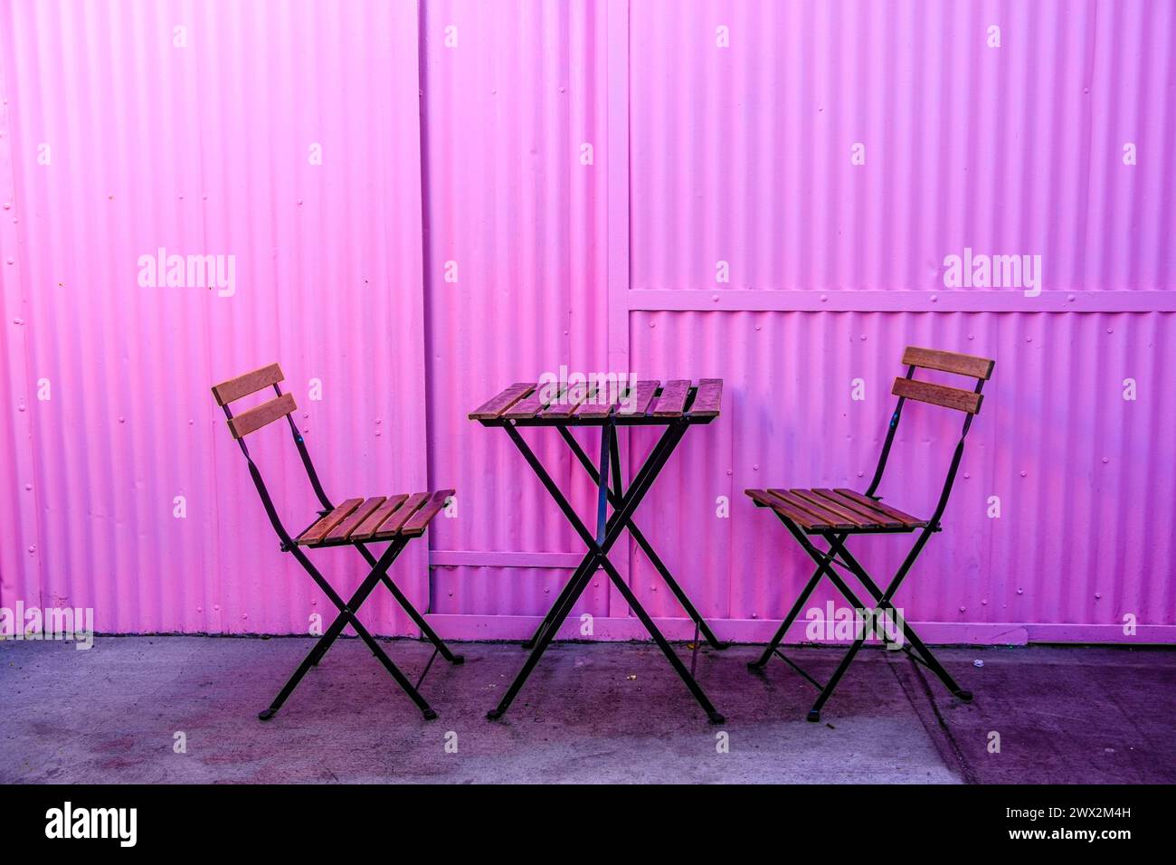 Lila Wand, Tisch und Stühle, Los Angeles, Kalifornien, USA. Stockfoto