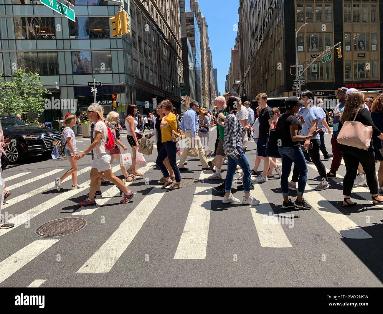 Fußgänger und Reisende gehen und überqueren die Straße während der Mittagspause in New York City Stockfoto