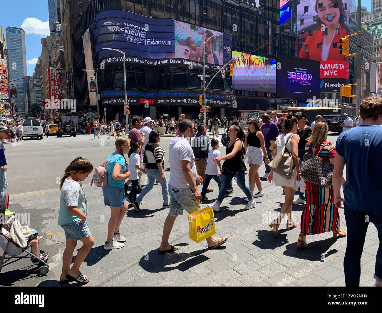 Auf der anderen Straßenseite des New Yorker Times Square spazieren zahlreiche Touristen und Familien Stockfoto