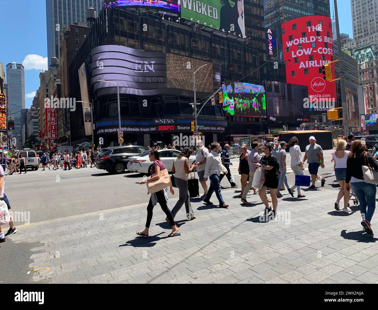 Fußgänger begeben sich an einem sonnigen Tag auf den Times Square in New York City Stockfoto