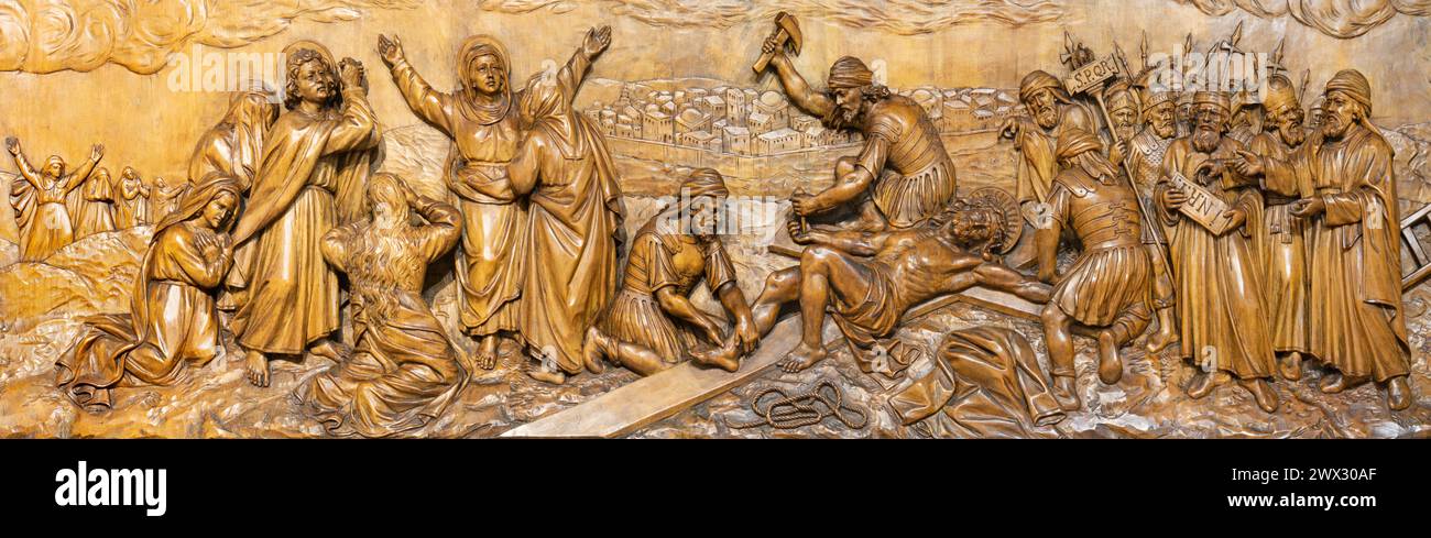 MAILAND, ITALIEN - 5. MÄRZ 2024: Das geschnitzte Relief Jesus wird in der Kirche Chiesa di San Camillo von Annibale Pagnoni (1900) an das Kreuz genagelt. Stockfoto