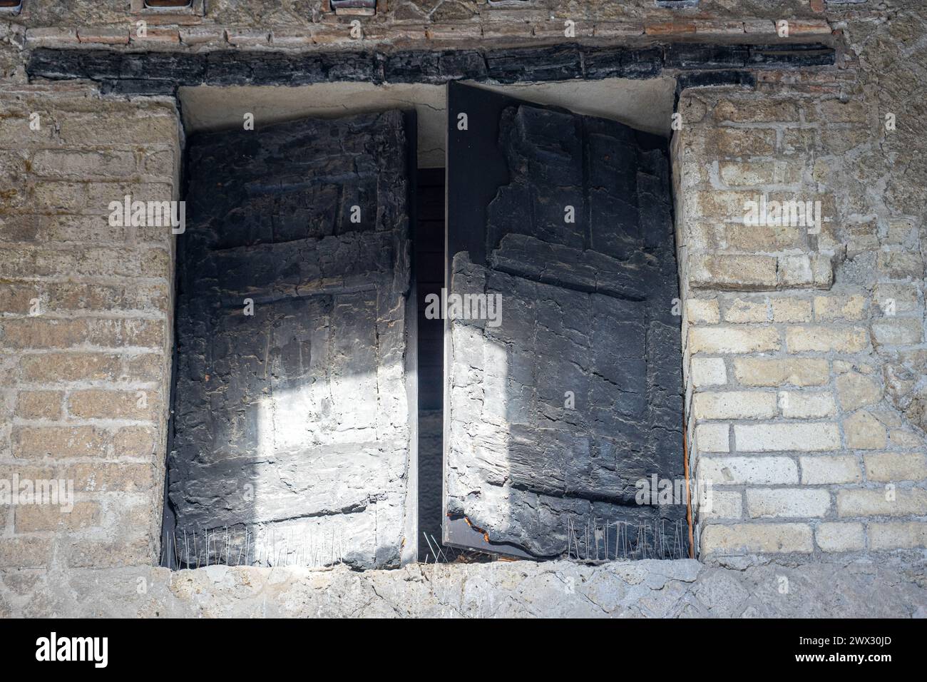 Verbranntes Holz von Originaltüren und Fenstern. Antike Stadt im archäologischen Park Herculaneum, Neapel, Italien Stockfoto