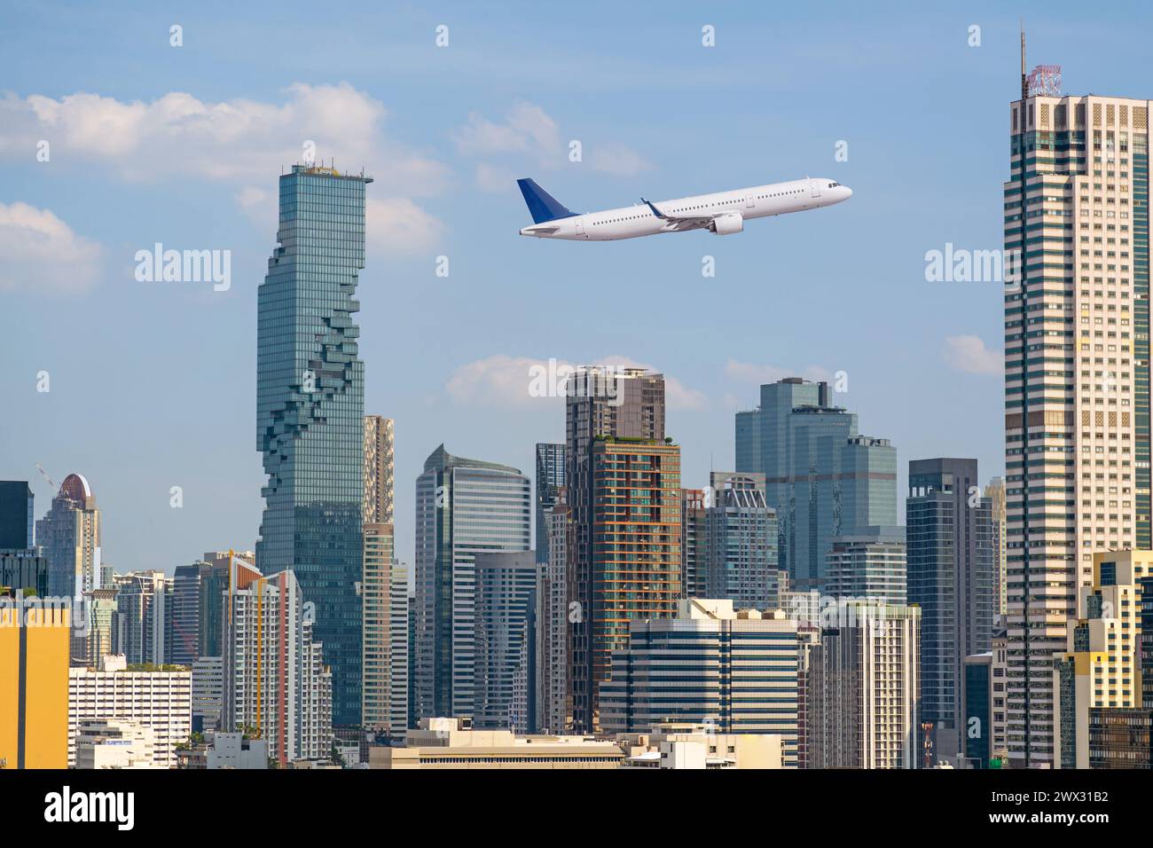 Fliegendes Passagierflugzeug am Himmel über der Stadt und Wolkenkratzer der Metropole. Das Konzept der Reise in ein modernes entwickeltes Land Stockfoto