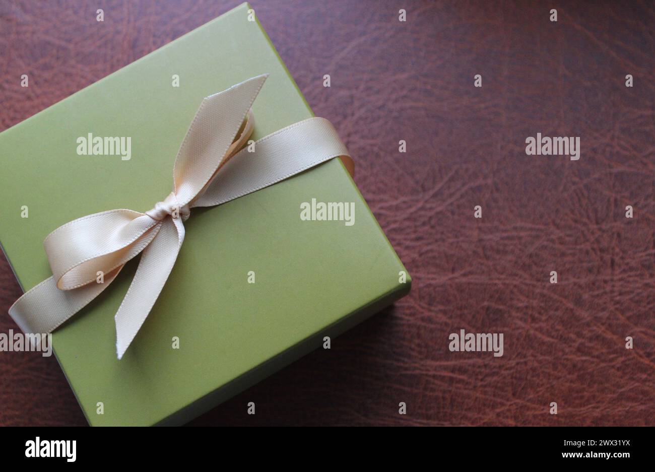 Elegante Geschenkbox auf Einer Lederoberfläche mit Draufsicht Concept Foto für Grußkarten oder Urlaubshintergründe Stockfoto