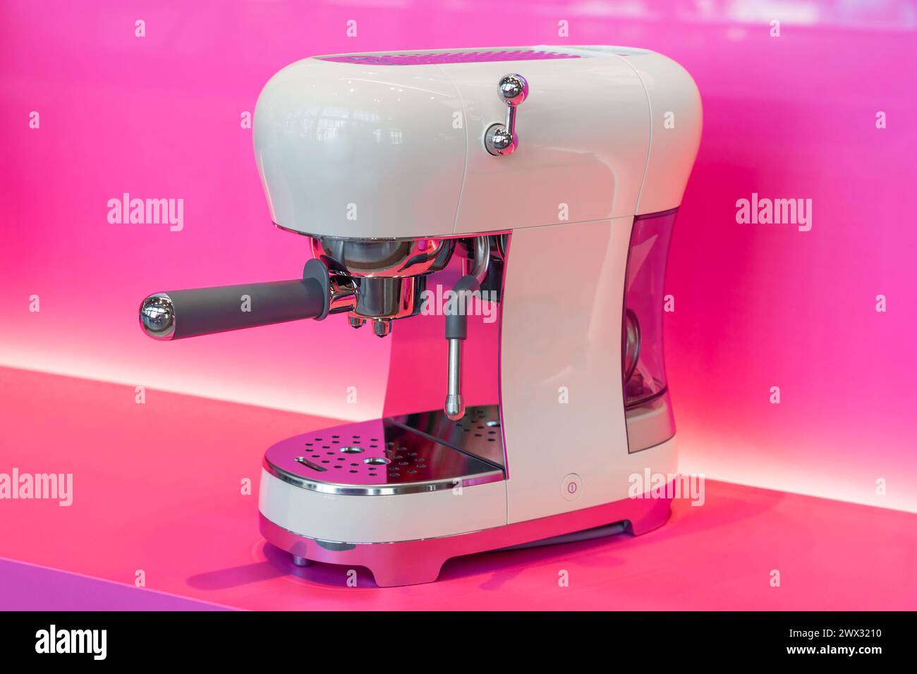 Kaffeemaschine mit Vintage-Retro-Look in moderner Technologie, weiß auf rosa Küchenhintergrund. Stockfoto