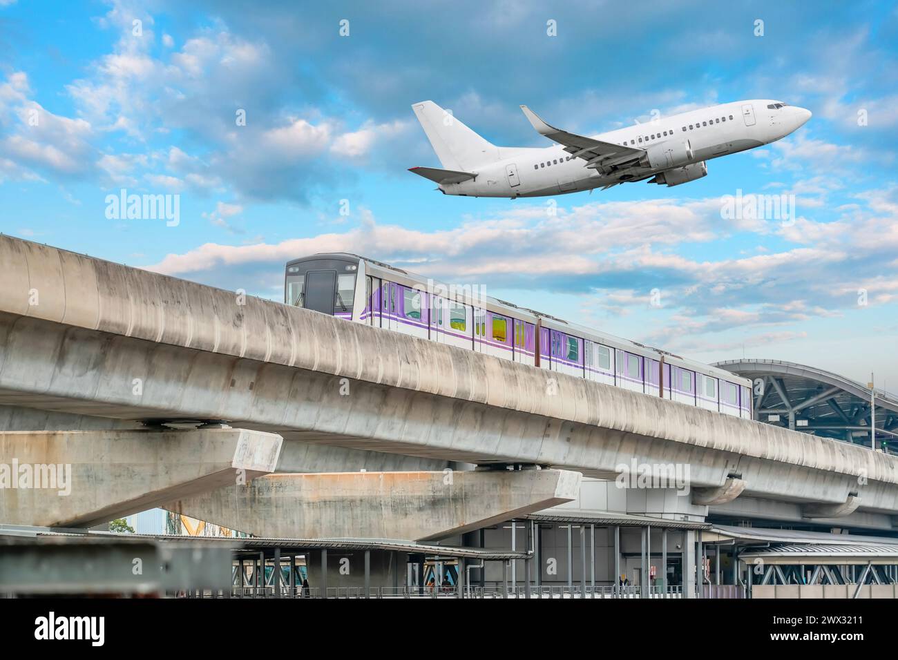 Sehen Sie sich die Bahngleise der U-Bahn an, die den Bahnhof mit elektrischem Zug abfährt. Passagierflugzeug fliegt im Himmel, landet am Flughafen. Konzept von Mo Stockfoto