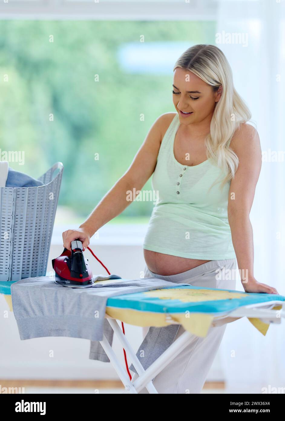 Schwangere Frau bügeln Stockfoto