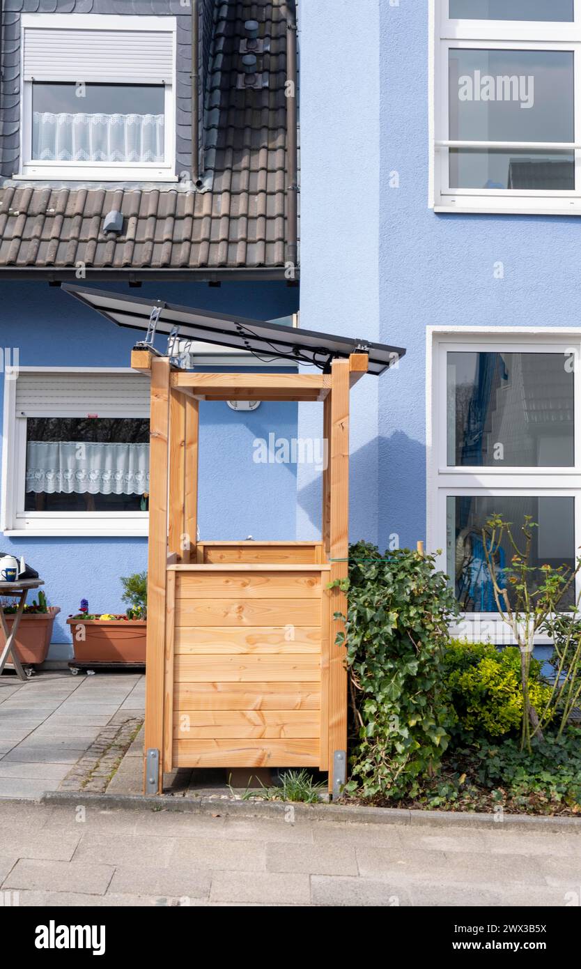 Freistehendes Haus mit verschiedenen Solarmodulen, neben Solarpaneelen auf dem Dach des Hauses, sind steckbare Solarmodule auf einer Mülltonne wie montiert Stockfoto