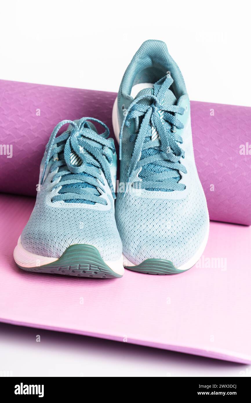 Turnschuhe und Yogamatte. Stockfoto