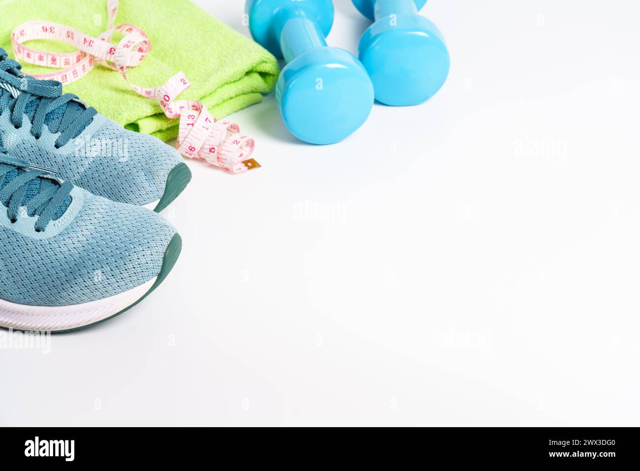 Turnschuhe, Kurzhanteln, grüner Apfel und Flasche Wasser isoliert auf weißem Hintergrund. Stockfoto