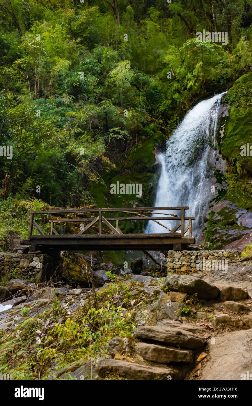 Ein Wasserfall mit Holzbrücke in Thangyam Village Taplejung, Kanchenjunga Trek, Nepal Stockfoto