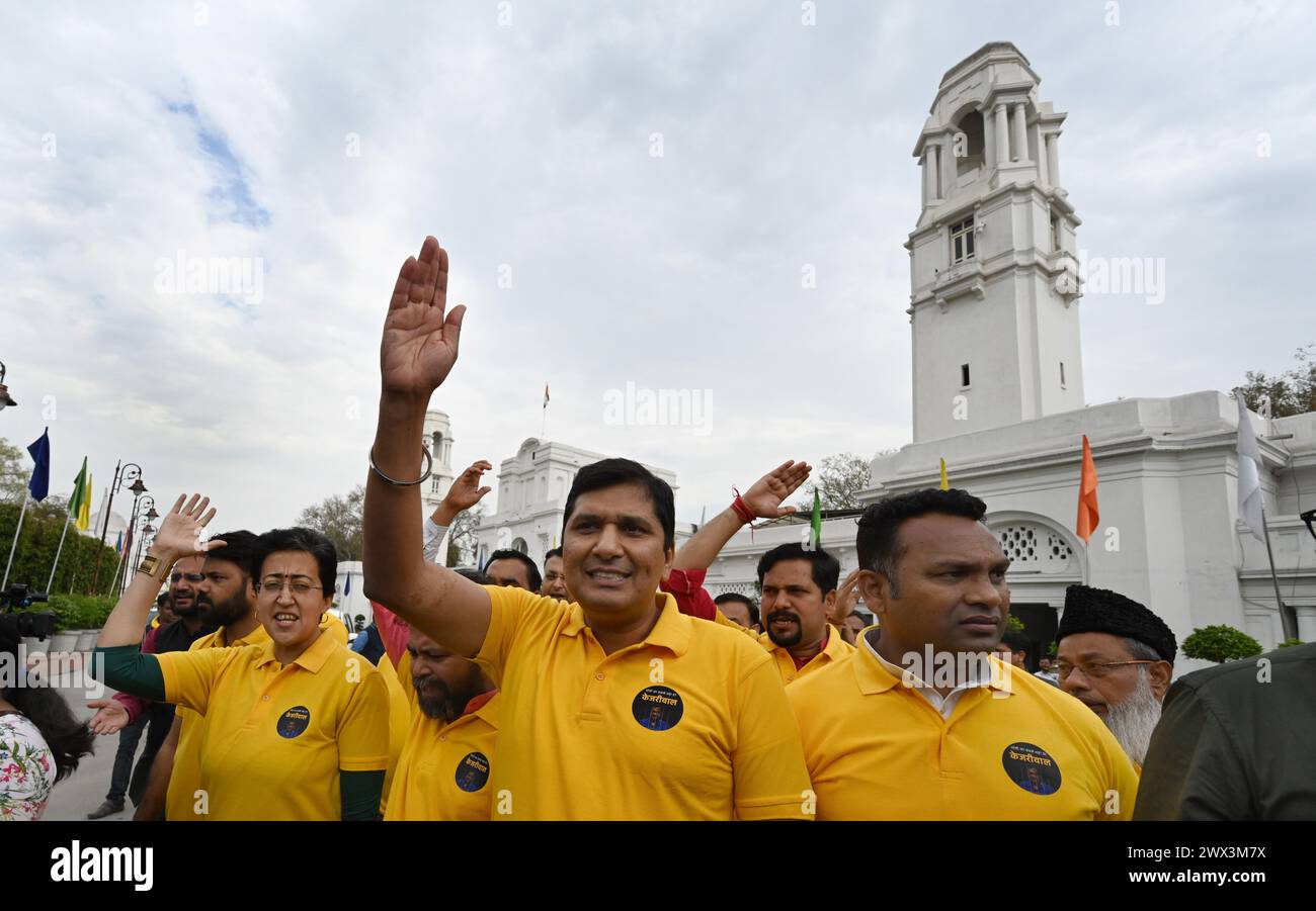 NEU-DELHI, INDIEN - 27. MÄRZ: die Delhi-Minister Saurabh Bharadwaj und Atishi sowie AAP MLAs brachten einen Slogan mit gelben T-Shirts mit Mei bhi Kejriwal auf der Rückseite während des Protests gegen die Festnahme von cm Arvind Kejriwal durch die Durchsetzungsdirektion (ED) am 27. März 2024 in Neu-Delhi, Indien. CM Kejriwal, der am 21. März verhaftet und anschließend bis zum 28. März von einem Gericht in Delhi in Untersuchungshaft gebracht wurde, sieht sich den Vorwürfen gegenüber, direkt an einer Verschwörung beteiligt zu sein, die sich auf die Formulierung einer Verbrauchsteuerpolitik zugunsten bestimmter Personen bezieht. (Foto von Stockfoto