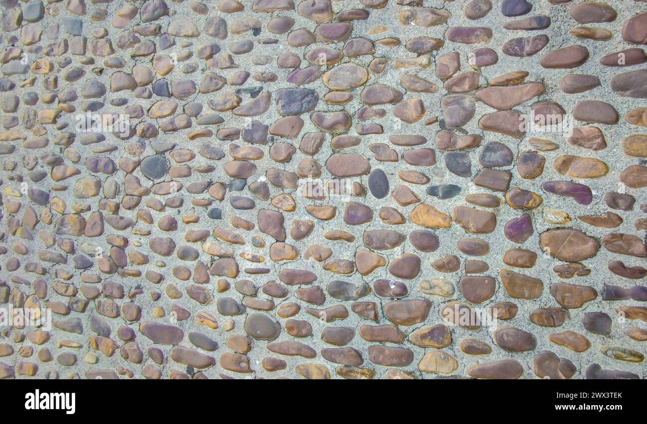 Kopfsteinpflaster aus kleinen Kieselsteinen. Monumentale komplexe Straßenoberflächen, Caceres, Spanien Stockfoto