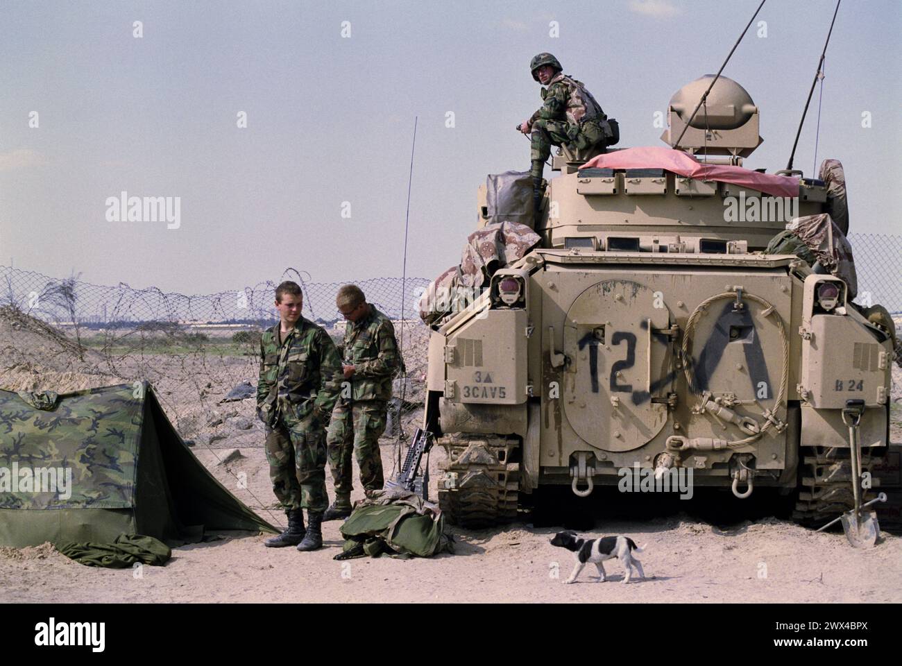 25. März 1991 Soldaten der US-Armee entspannen sich neben ihrem Kampffahrzeug Bradley Kavallerie an der Grenze zum Irak im Norden Kuwaits. Stockfoto