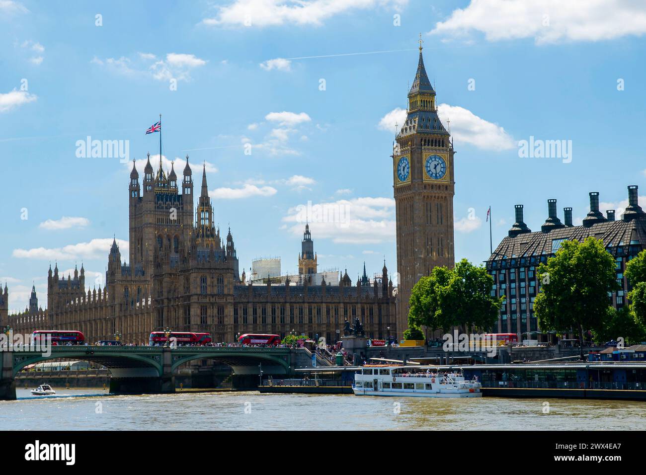 Big Ben und die Houses of Parliament, Wahrzeichen Londons, sonnen sich im Sonnenschein entlang der lebhaften Themse Stockfoto
