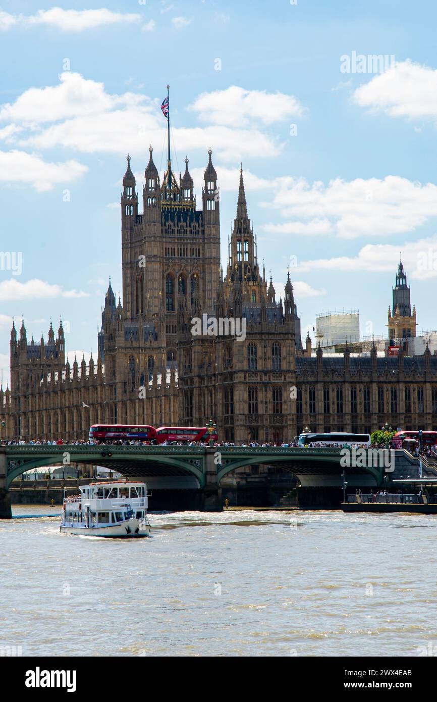Londons berühmte Houses of Parliament und Big Ben überragen an einem hellen, sonnigen Tag die geschäftige Themse. Stockfoto