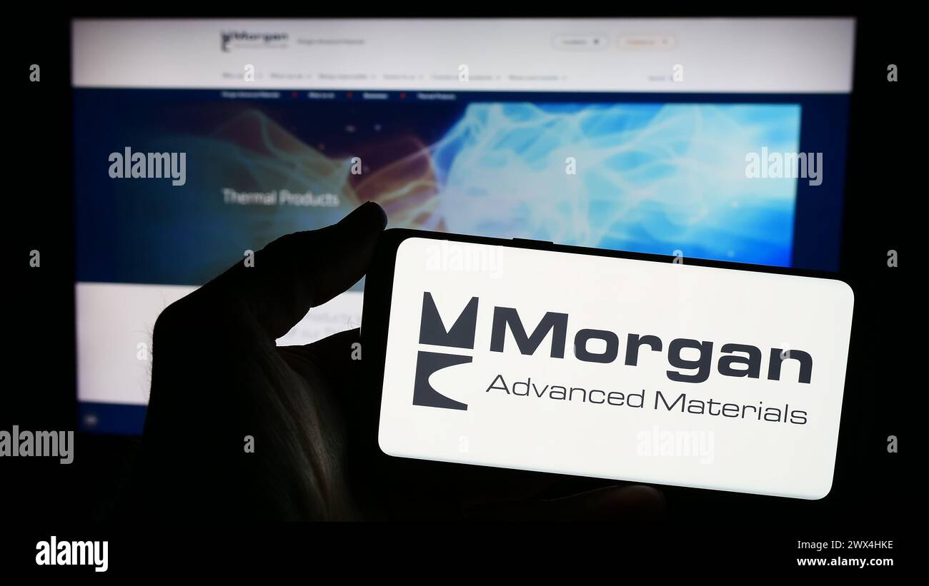 Person mit Smartphone und Logo des britischen Unternehmens Morgan Advanced Materials plc vor der Website. Schwerpunkt auf dem Display des Telefons. Stockfoto