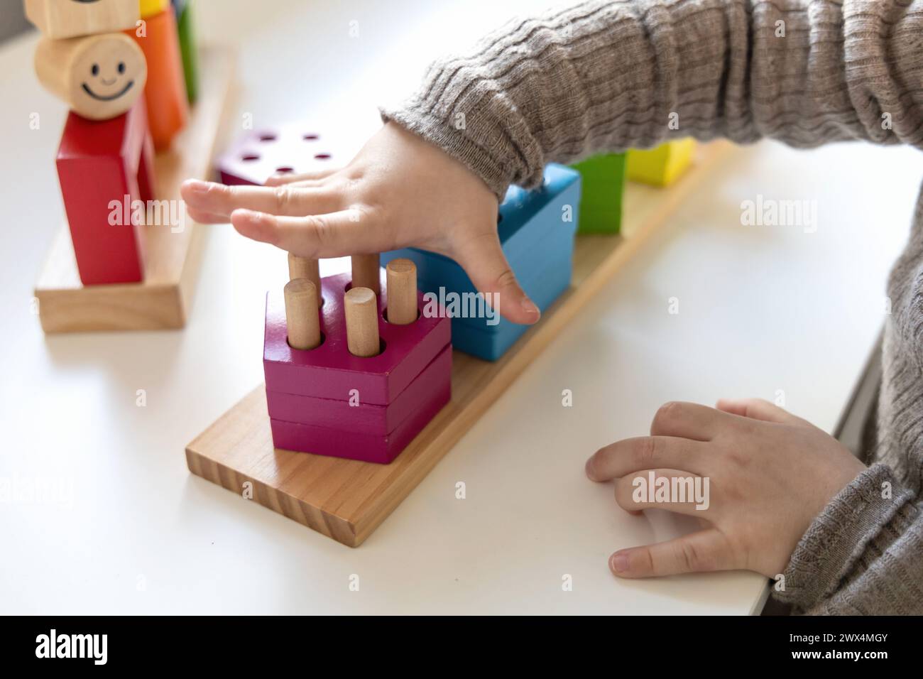 Ein Kind spielt mit bunten Holzblöcken ein lustiges Logikspiel. Tag und Nacht Spiel der Logik. Lernspiele für Kinder und früher entwickeln sich Stockfoto