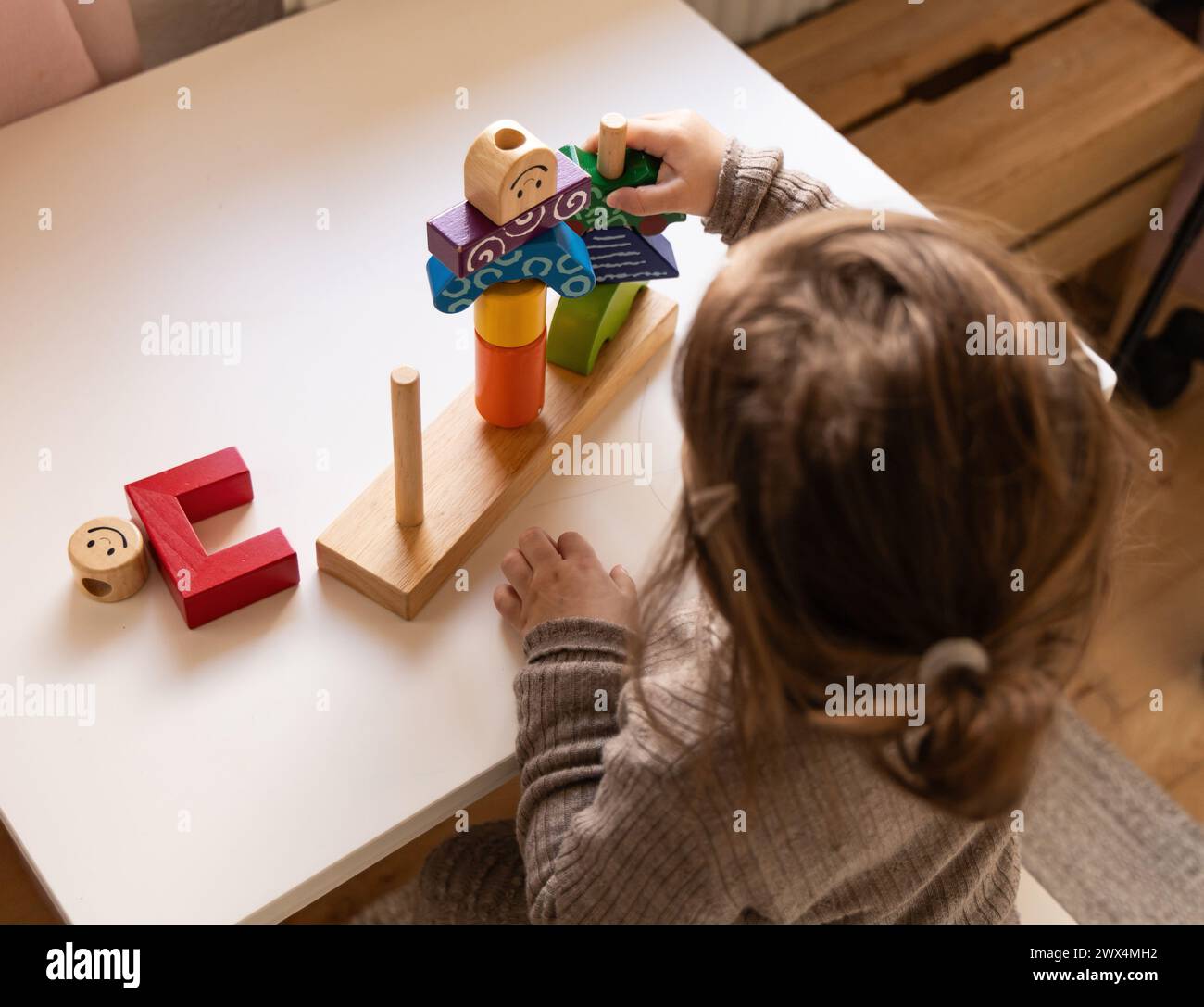Ein Kind spielt mit bunten Holzblöcken ein lustiges Logikspiel. Tag und Nacht Spiel der Logik. Lernspiele für Kinder und früher entwickeln sich Stockfoto