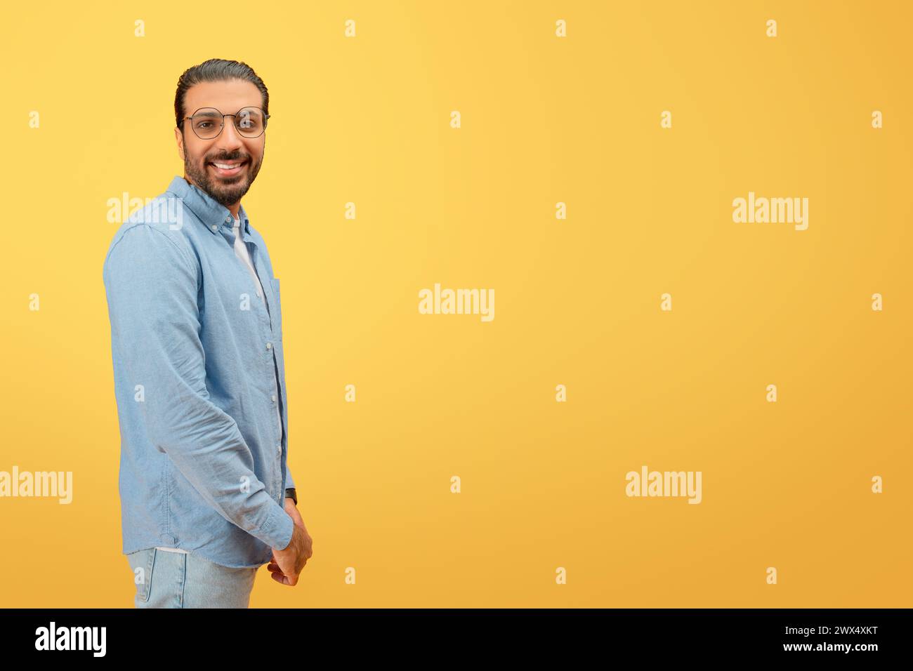 Mann in Denim lächelt und steht selbstbewusst Stockfoto