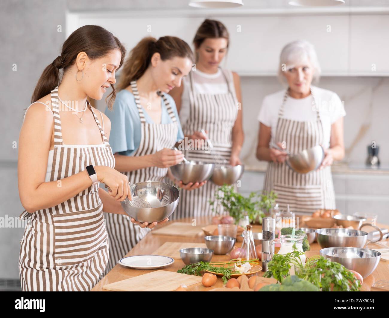 Mädchen während des Studiums in einem kulinarischen Workshop kocht sie appetitliche Soße, Marinade und Teig in einer Schüssel. Stockfoto