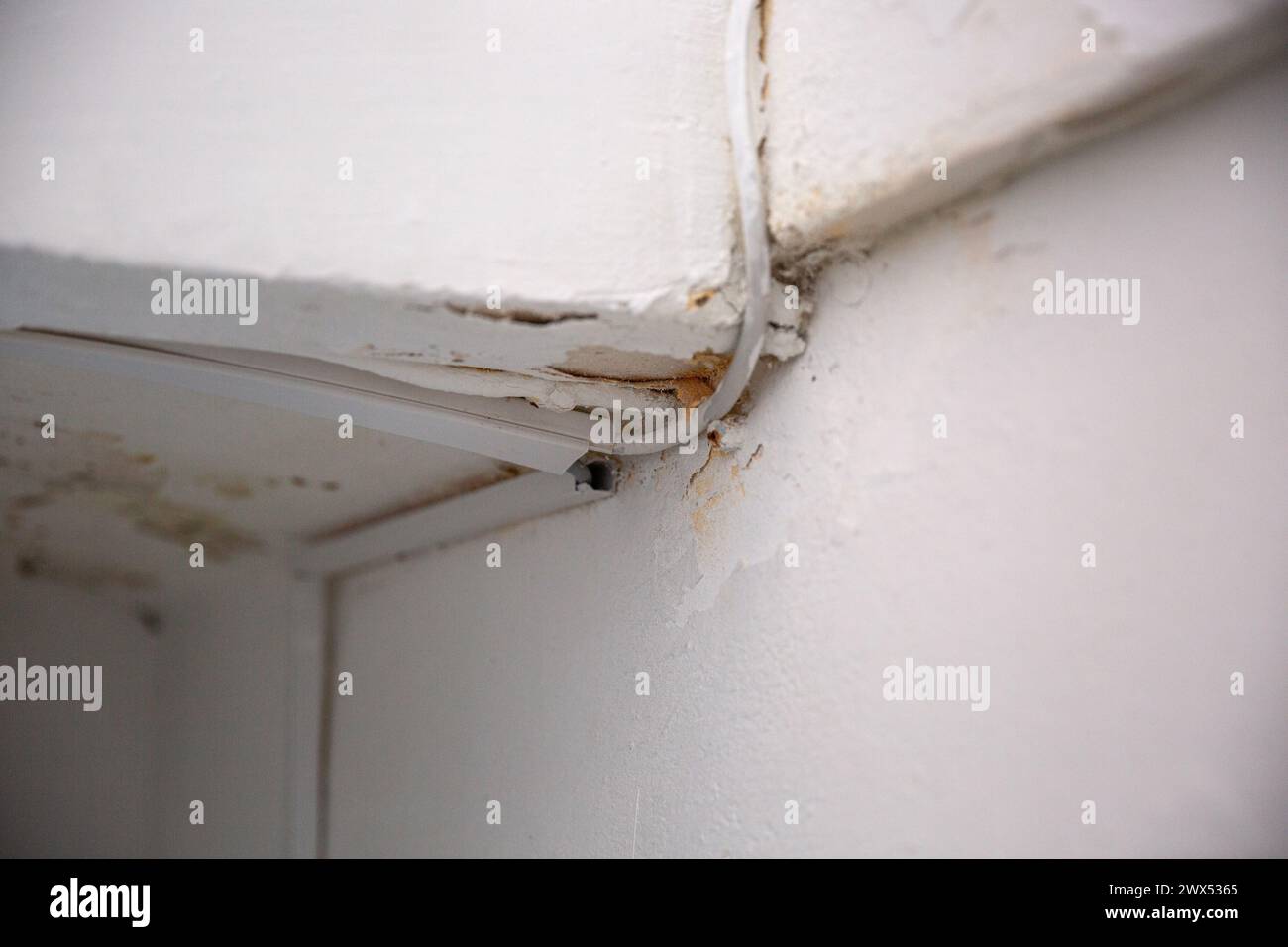 Defekte Elektrokabel an der weißen Wand Stockfoto