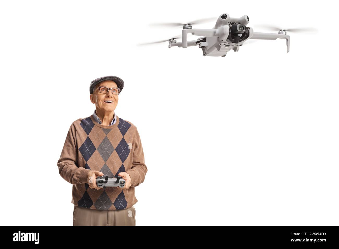 Senior Mann, der eine Drohne mit einer Fernbedienung auf weißem Hintergrund fliegt Stockfoto