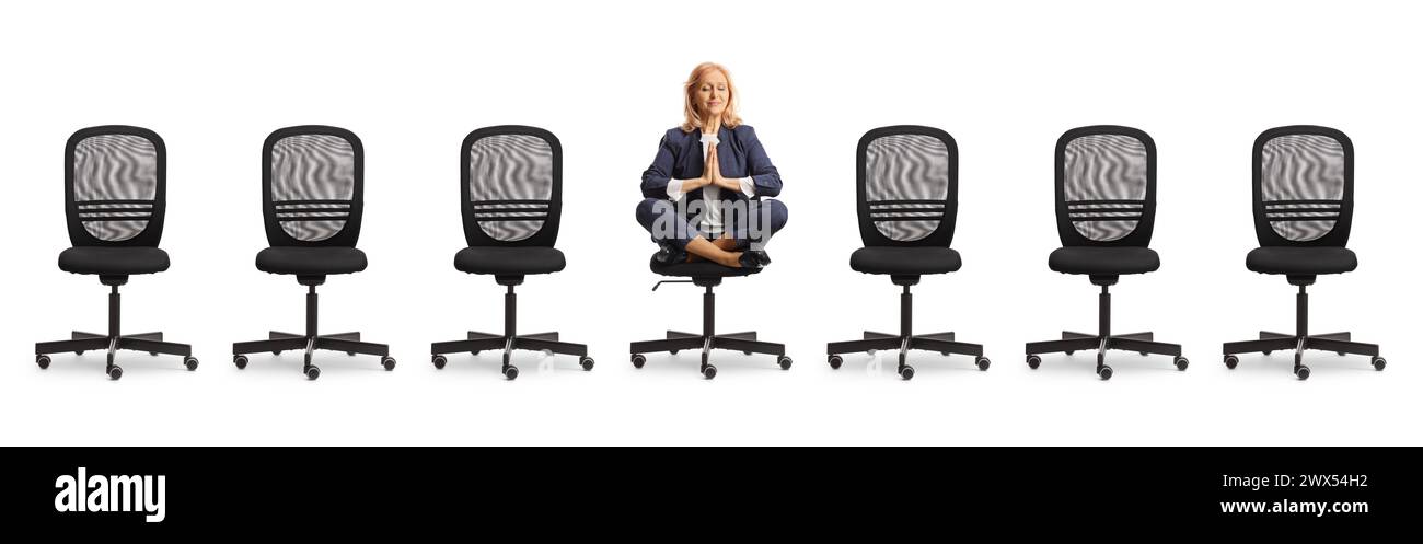 Geschäftsfrau sitzt und übt Yoga zwischen leeren Stühlen auf weißem Hintergrund Stockfoto