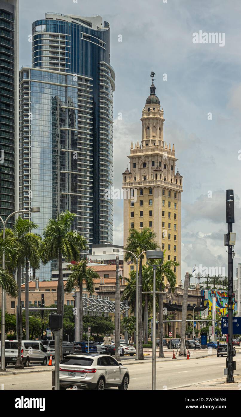 Miami, Florida, USA - 29. Juli 2023: Historischer Freedom Tower am Miami Dade College mit einem Wolkenkratzer dahinter. Biscayne blvd Straßenszene mit Autoverkehr Stockfoto