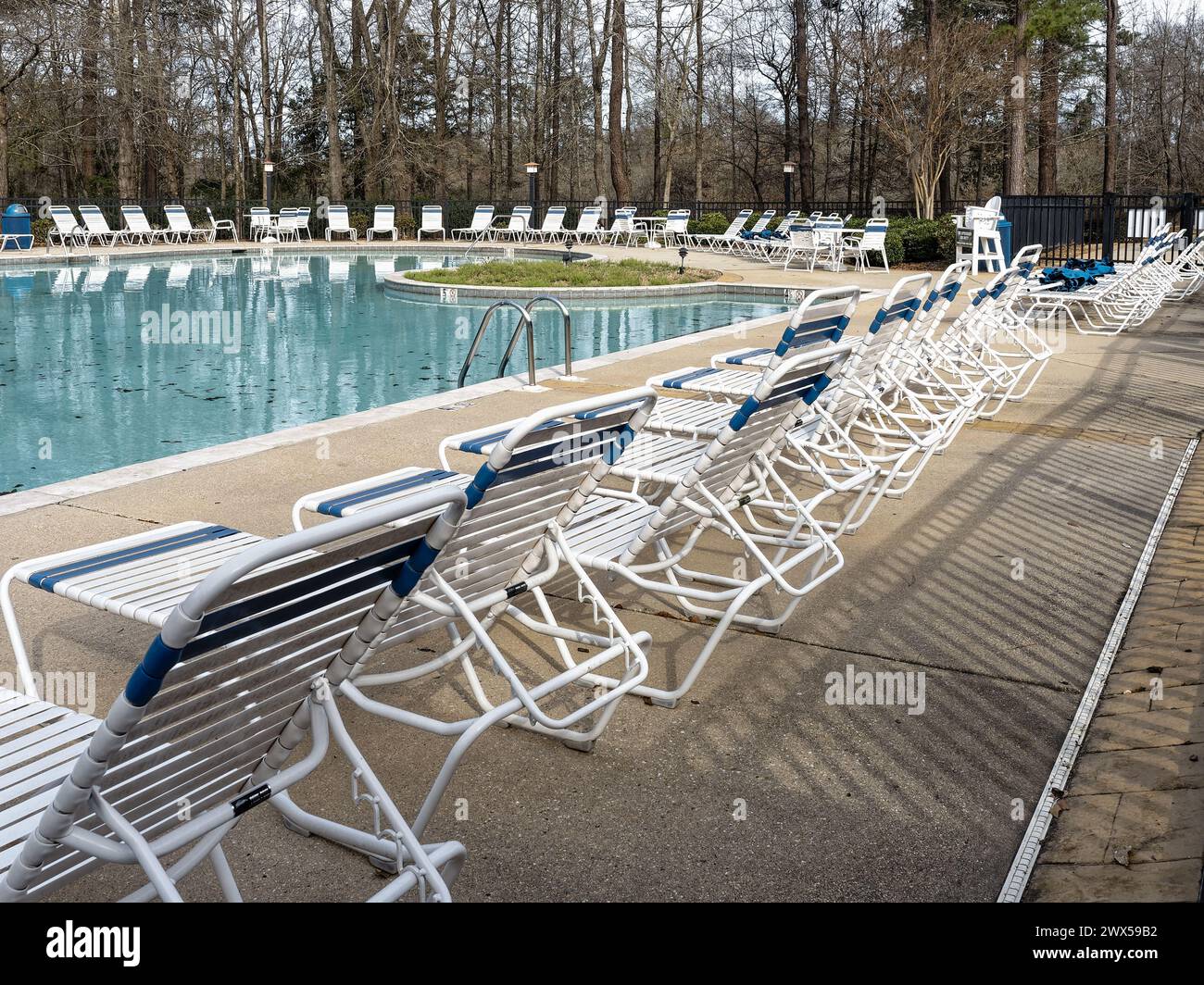 Poolterrasse mit Liegestühlen, die auf die Menschenmassen im Sommer warten, an einem großen Swimmingpool in einer Wohnsiedlung in Pike Road Alabama, USA. Stockfoto