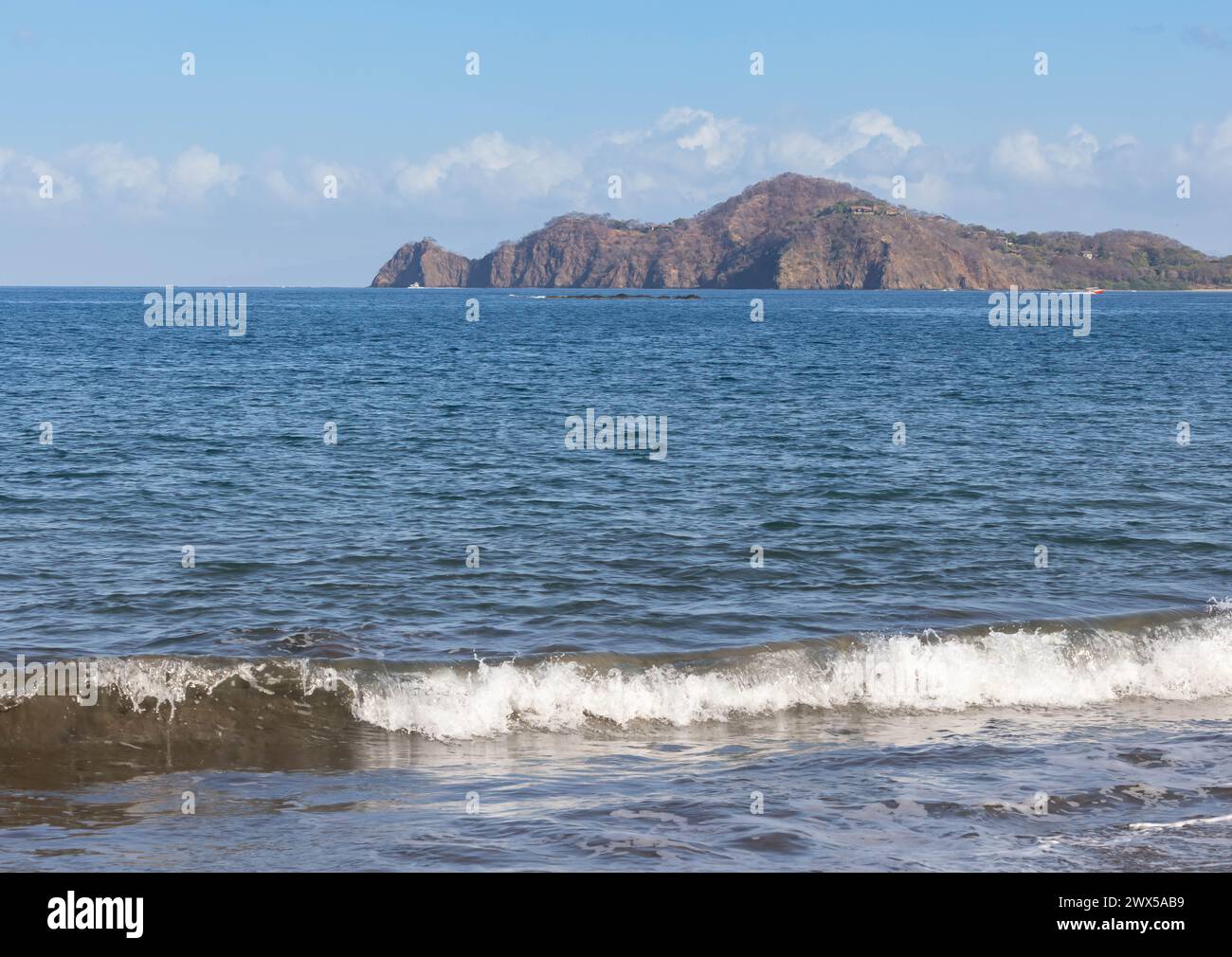 Winken Sie in der Nähe des Strandes und der Insel in der Ferne in Playa Hermosa Costa Rica Stockfoto