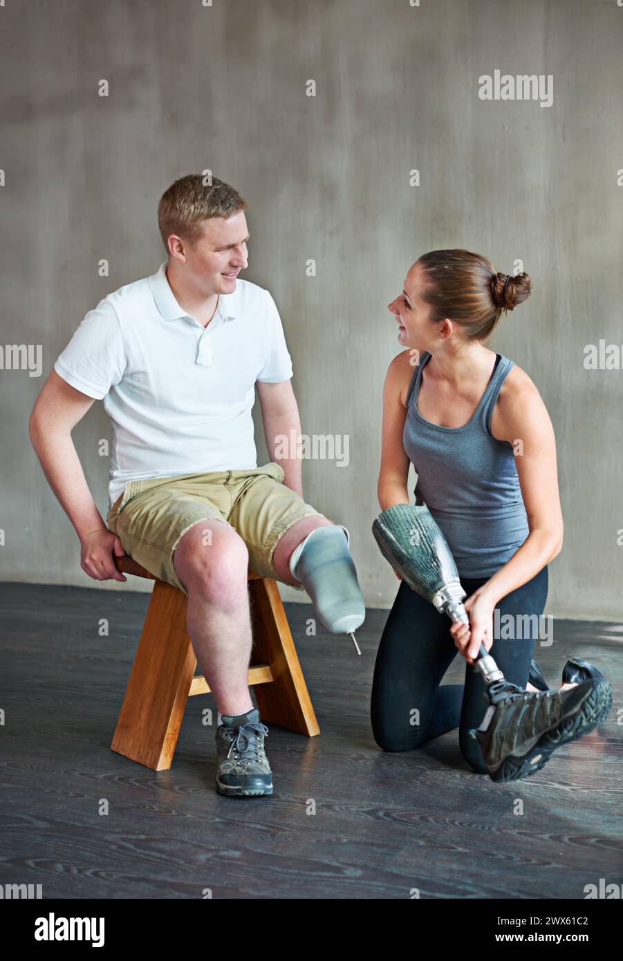 Mann, Frau und Physiotherapie mit Prothetik, Sitzung und Bein bei Rehabilitation, Bewegung und Training. Physiotherapeut, Patient und Fitness Stockfoto