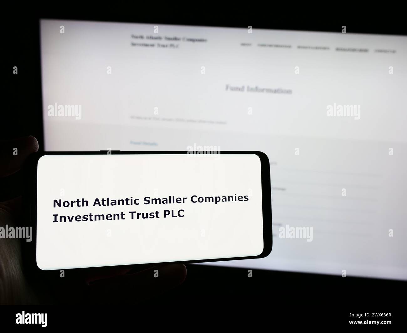 Person, die ein Smartphone mit dem Logo von North Atlantic Small Companies Investment Trust plc vor der Website hält. Schwerpunkt auf dem Display des Telefons. Stockfoto