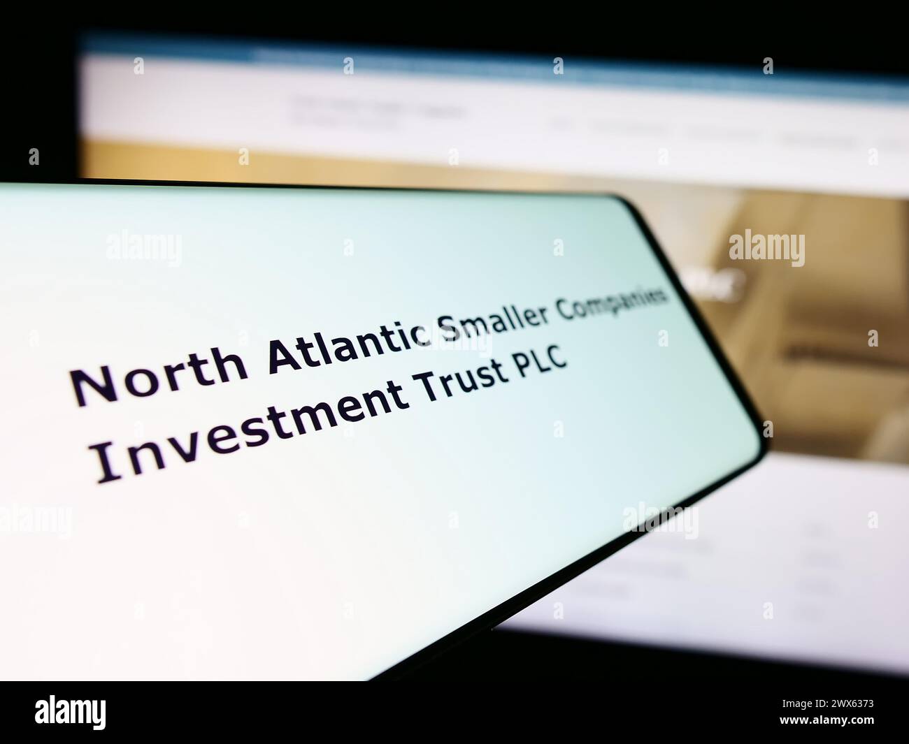 Smartphone mit Logo von North Atlantic Small Companies Investment Trust plc vor der Website. Fokussieren Sie sich auf die linke Mitte des Telefondisplays. Stockfoto