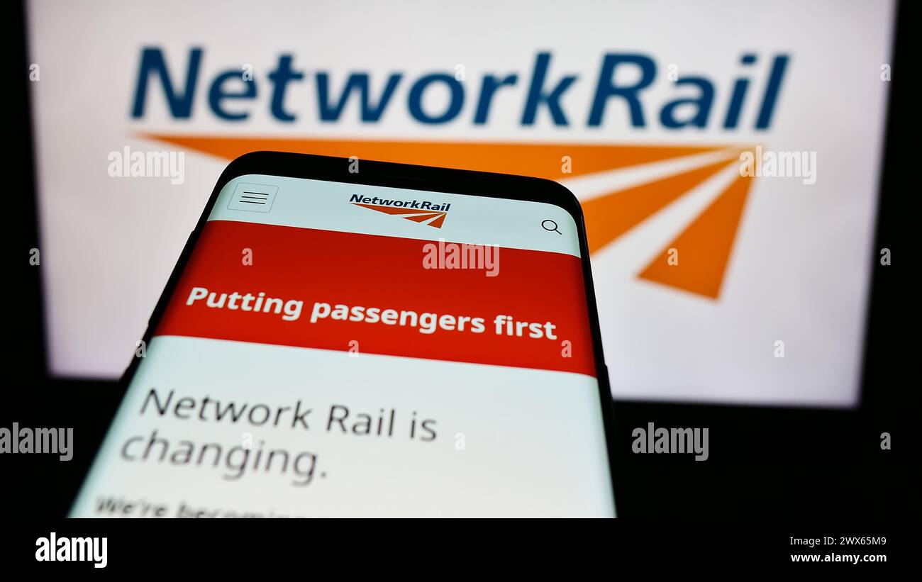 Mobiltelefon mit Website des Eisenbahninfrastrukturunternehmens Network Rail Limited vor dem Geschäftslogo. Fokussieren Sie sich oben links auf der Telefonanzeige. Stockfoto