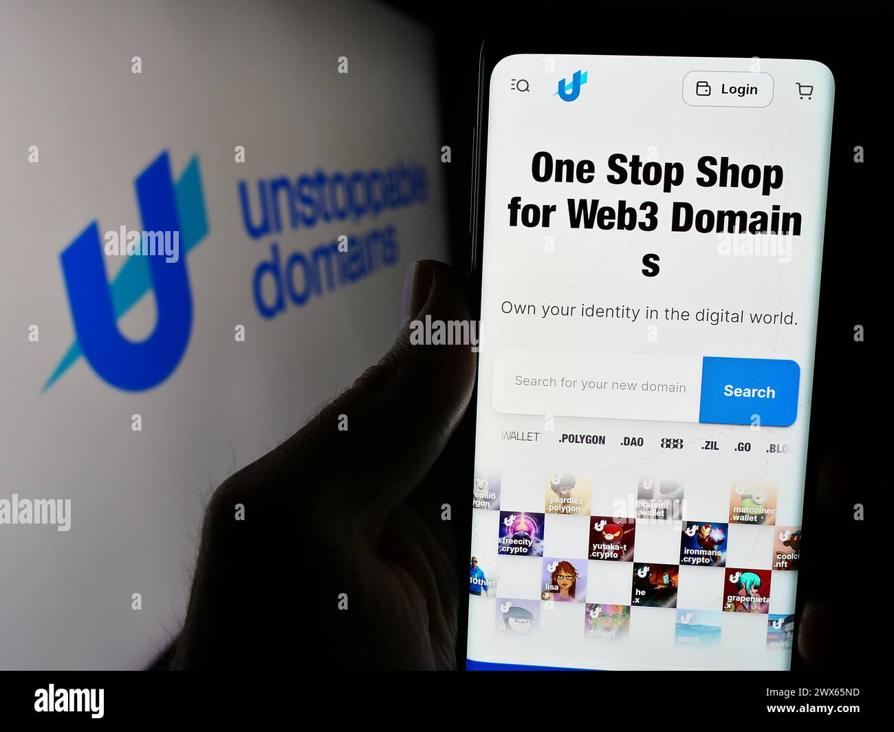 Person, die ein Handy hält, mit der Webseite des US-Blockchain-Unternehmens Unstoppable Domains Inc. Vor dem Logo. Konzentrieren Sie sich auf die Mitte des Telefondisplays. Stockfoto