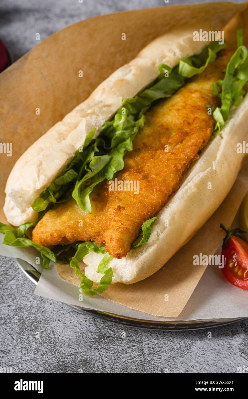 Gebratenes Fisch-Sandwich mit Gemüse auf dem Steintisch. Türkischer Name Balik Ekmek Stockfoto