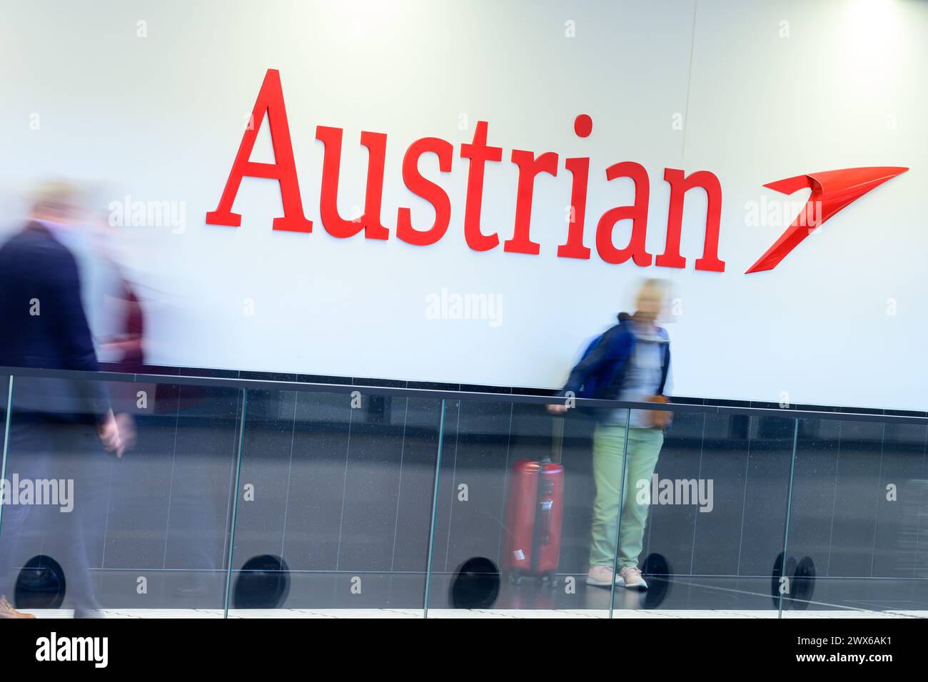 28.03.2024, Schwechat, AUT, 36-stündiger Streik des Bordpersonals der Austrian Airlines im Bild .das Austrian Airlines Logo mit Passagieren davor // das Logo der Austrian Airlines mit Passagieren davor, das während des 36-stündigen Streiks des Bordpersonals der Austrian Airlines aufgezeichnet wurde. Schwechat, Österreich am 2024/03/28 - 20240328 PD1179 Stockfoto