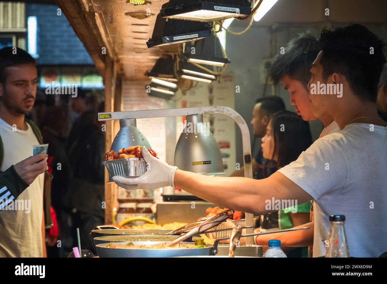 London, Großbritannien - 12. September 2023 - Mitarbeiter servieren chinesische Speisen zum Mitnehmen für Kunden auf dem Camden Street Food Market Stockfoto